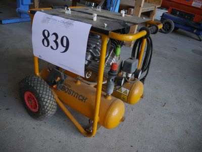 a small air compressor sitting on a cart in the garage