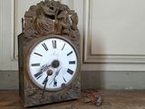 a clock that is sitting on the floor next to a wall
