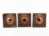 trois enceintes en bois marron dotées d'un bouton noir et doré