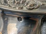 a silver vase that has a handle on it