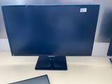 a computer monitor sitting on top of a desk next to a laptop