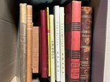 many books that are in a box on the shelf