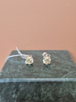 boucles d'oreilles à tige plaquées argent, ornées de cristaux transparents, présentées sur un socle en marbre