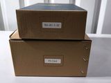 two brown boxes sitting on top of a white table next to each other
