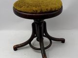 une image représentant un petit tabouret sur lequel est posé un coussin jaune
