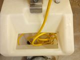 a white sink with a yellow hose in it