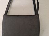 the small black bag is sitting on a white surface