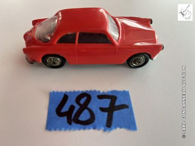 une petite voiture rouge posée à côté d'une feuille de papier bleue sur laquelle sont inscrits les lettres « u » et « f »