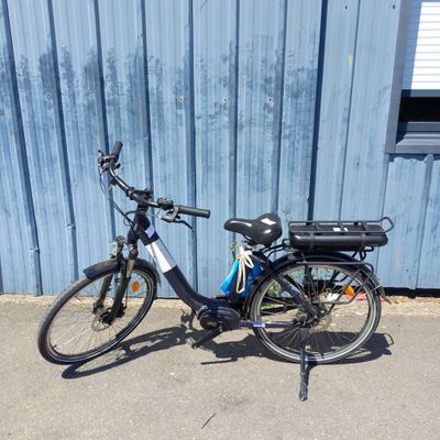un vélo garé à côté d'un immeuble bleu