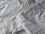 deux paires de pantalons blancs posées sur un lit