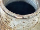 a close up of a vase with a black substance in it