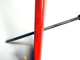 a red toothbrush with a black handle on a white surface