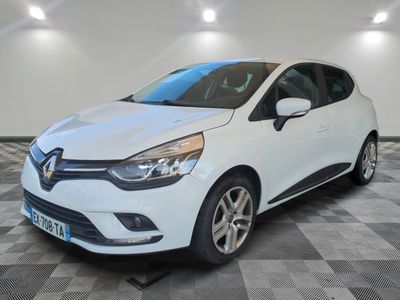 une voiture blanche est garée dans une pièce au sol à carreaux
