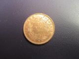a gold coin sitting on top of a black surface