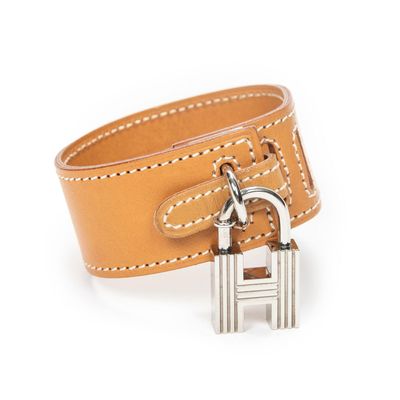 a close up of a leather bracelet with a padlock on it