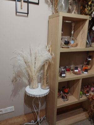 a tall wooden shelf with a vase on top of it