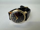 a black and gold wrist watch on a white surface