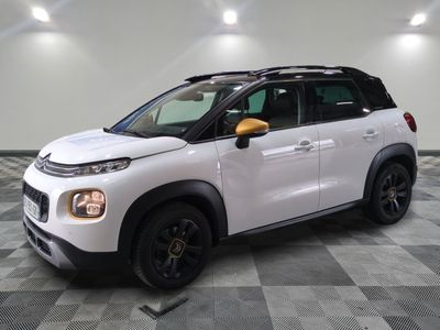 La Citroën blanche est garée dans une grande pièce au sol carrelé en damier.