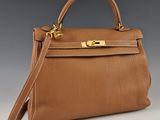 un sac à main en cuir marron avec des ferrures dorées sur la poignée