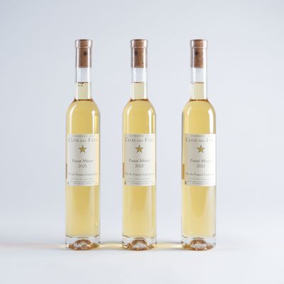trois bouteilles de vin blanc posées l'une à côté de l'autre sur une surface blanche