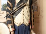 a mannequin dressed in a military uniform with a drum in front of a window