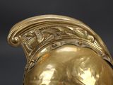 a gold helmet with a dragon on it on a black background