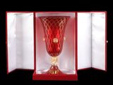 un vase en verre rouge dans une boîte rouge sur fond noir