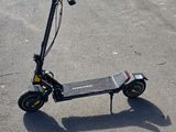 a scooter that is sitting on the ground in the parking lot