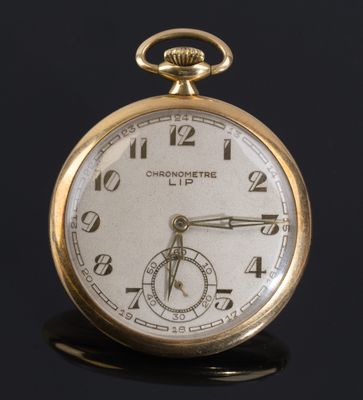 une montre de poche antique sur une surface noire avec un fond noir