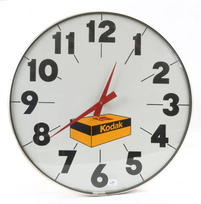 une horloge sur laquelle est posée une boîte de Kodak