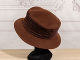 a brown hat sitting on a black hat stand