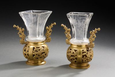 une paire de vases en or et en cristal posés sur une table