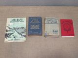 several books are lined up on a table with a brown cloth