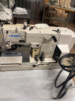 une machine à coudre blanche posée sur une table dans une pièce