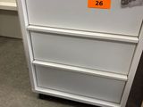 a white filing cabinet with a key on top of it