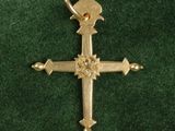 gold plated cross on green velvet with a diamond center