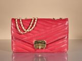 pink purse with chain strap and clasp on a shiny surface