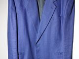 une veste de costume bleue suspendue à un cintre sur un mur blanc