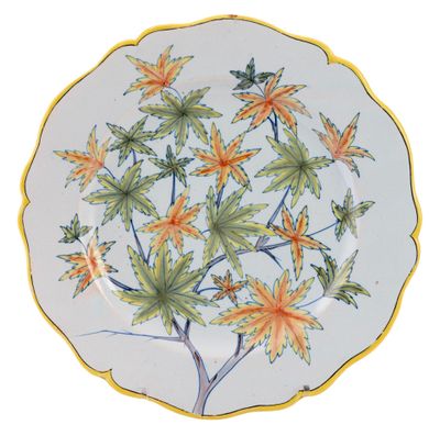 a plate with a yellow and green leaf design on it