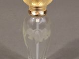 a glass bottle with a gold lid on a gray surface