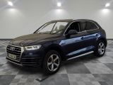 un SUV Audi bleu garé sur un sol à damier dans un showroom
