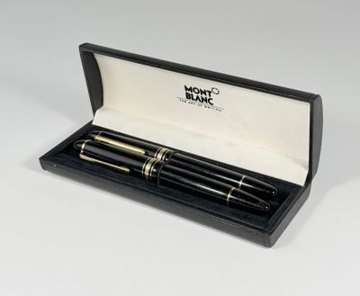 des stylos à plume noirs et dorés dans un coffret noir posé sur une surface blanche