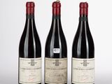 trois bouteilles de vin sont alignées sur une table
