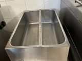 une grande friteuse en acier inoxydable trônant au milieu d'une cuisine