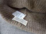 a picture of a label on a sweater that is on a chair