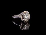 une image d'une bague en diamant sur une surface noire
