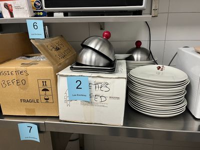 many plates and pans sitting on a shelf in a kitchen