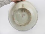a person holding a white bowl with writing on it
