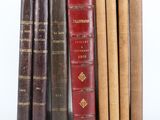 plusieurs vieux livres sont alignés sur une surface blanche