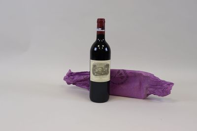 une bouteille de vin posée à côté d'un sac violet